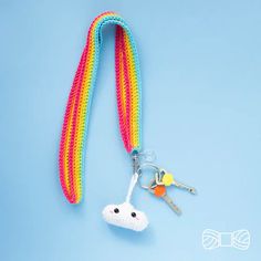 a crocheted keychain with a rainbow colored lanyard attached to it