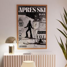 a poster hangs on the wall next to a table with a lamp and chair in front of it