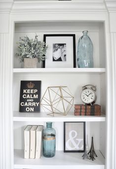 a white book shelf filled with books and pictures