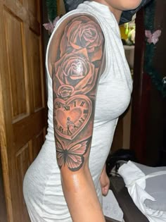 a woman with a clock and roses tattoo on her arm is posing for the camera