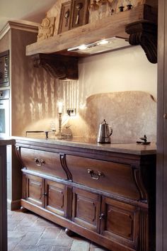 an old fashioned kitchen with wooden cabinets and marble counter tops