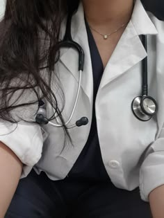 a woman wearing a white coat with a stethoscope on her chest and arm