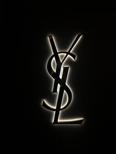 a black and white photo of the y logo on a dark wall with light coming from it