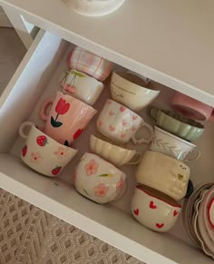 a drawer filled with lots of cups and saucers