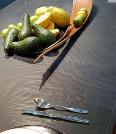 a table topped with lots of different types of fruits and veggies next to a knife