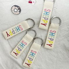 three keychains with the words sherpay spelled on them next to donuts