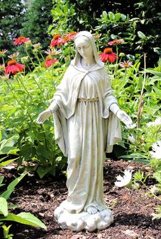 a statue of the virgin mary in a garden