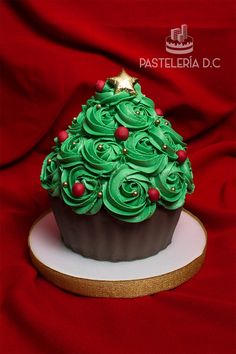 a cupcake decorated with green frosting and red berries