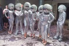 several people in shiny silver suits standing next to each other