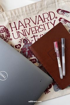 an open laptop computer sitting on top of a table next to a notebook and pen