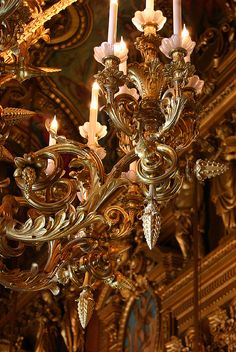 an ornate chandelier with candles lit in the middle