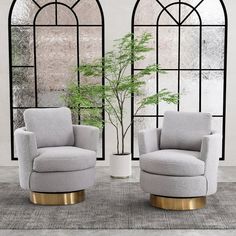 two gray chairs sitting next to each other in front of a window with arched windows