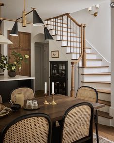 a dining room table with chairs and a chandelier hanging from the ceiling above it