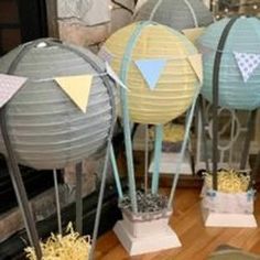 several paper lanterns sitting on top of a wooden floor