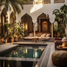 an indoor swimming pool surrounded by potted plants and seating area with candles on the tables