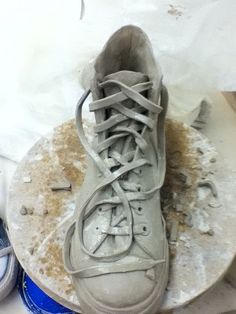 a dirty pair of shoes sitting on top of a table next to a can of soda