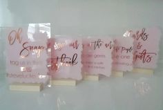 four pieces of pink paper with writing on them are hanging in a glass display case