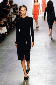 models walk down the runway in black dresses