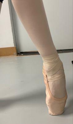 a ballerina's feet in ballet shoes on the floor