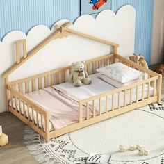 a baby crib with a teddy bear sitting on it in front of a blue wall