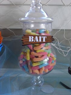 a glass jar filled with colorful candies on top of a table