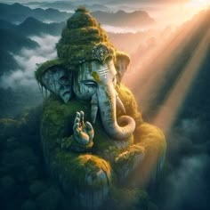 an elephant statue sitting on top of a lush green hillside covered in fog and sunlight