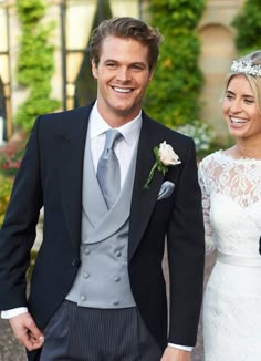 a man in a suit and tie standing next to a woman wearing a wedding dress