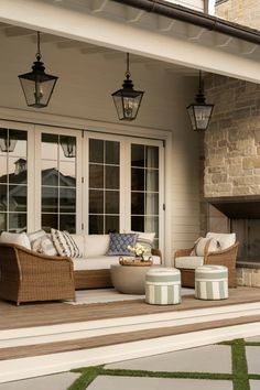 an outdoor living area with wicker furniture and lanterns on the ceiling, along with grass