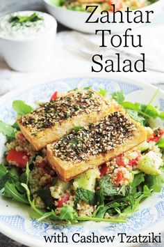 two tofu slices on top of a salad with sesame seeds and garnishes