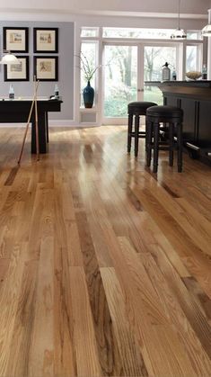 an open kitchen with hardwood floors and white walls in the background is a dining room