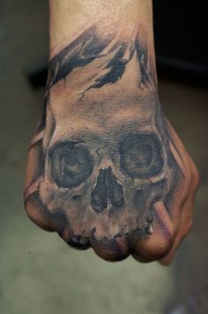 a hand with a skull on it and two birds flying over the top of it