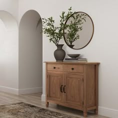 a wooden cabinet sitting next to a mirror on top of a wall in a living room