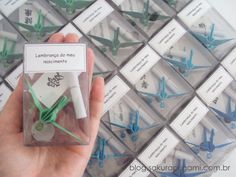 a person holding up some origami airplanes in a box with labels on them