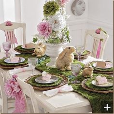 the table is set for easter dinner with bunny decorations