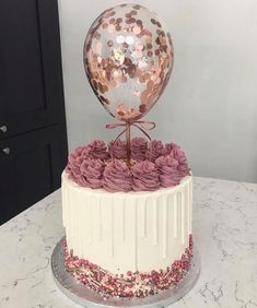 a white cake with pink frosting roses and a large mirror ball on the top