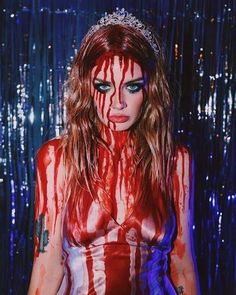 a woman with blood all over her body and makeup