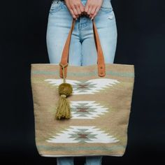 A gorgeous oversized tote bag in a green combo Aztec pattern with sturdy leather straps to carry everything you need! Take her to the Hamptons for the weekend or pack a change of clothes for yoga (a yoga mat fits pretty well!) - this tote will become an absolute every day favorite! DETAILS:• Tan, light green, olive & brown color, Aztec pattern• Light green pom tassel detail (can be removed)• Leather straps• 17"x 6.5"x 14.5" • 60% Cotton / 40% Wool• Magnetic button closure Southwestern Style Tote Bag For Everyday Use, Everyday Tapestry Tote Bag, Bohemian Style Tote Bag For On-the-go, Aztec Backpack, Oversized Tote Bag, Oversized Tote, Green Olive, Aztec Pattern