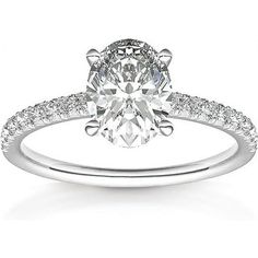 a white gold engagement ring with an oval cut diamond and pave set diamonds on the band