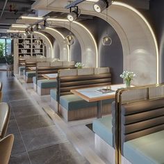 the interior of a restaurant with tables and benches