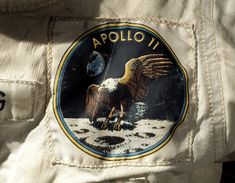 an astronaut's badge on the back of a white space suit, with earth in the background