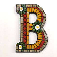 the letter b is made up of stained glass and has daisies on each side