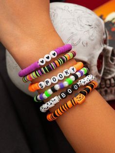 a person wearing bracelets that say spooky on their wrist and skull in the background