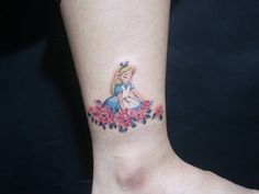 a small tattoo on the ankle of a girl with flowers and a princess's face