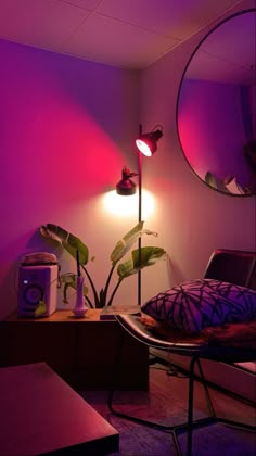 a living room with purple lighting and plants in the corner, along with a round mirror on the wall