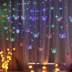 a living room filled with lots of lights next to a window covered in butterfly decorations