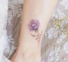 a woman's foot with a rose tattoo on the left side of her ankle