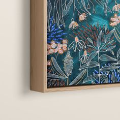 a painting hanging on the wall with flowers and plants painted on it's side