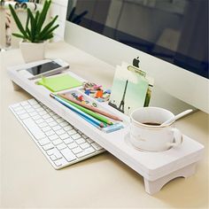 a computer desk with a keyboard, mouse and coffee cup on it's tray