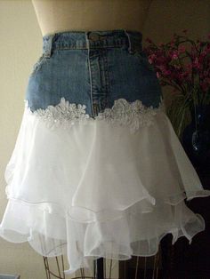 a white skirt with ruffles and lace on the bottom is displayed in front of a mannequin