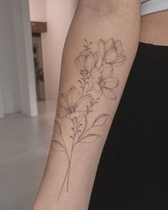 a woman's arm with flowers on it, and a tattoo that is in the shape of a flower